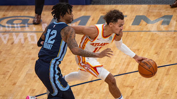Atlanta Hawks guard Trae Young dribbles past Memphis Grizzlies guard Ja Morant.